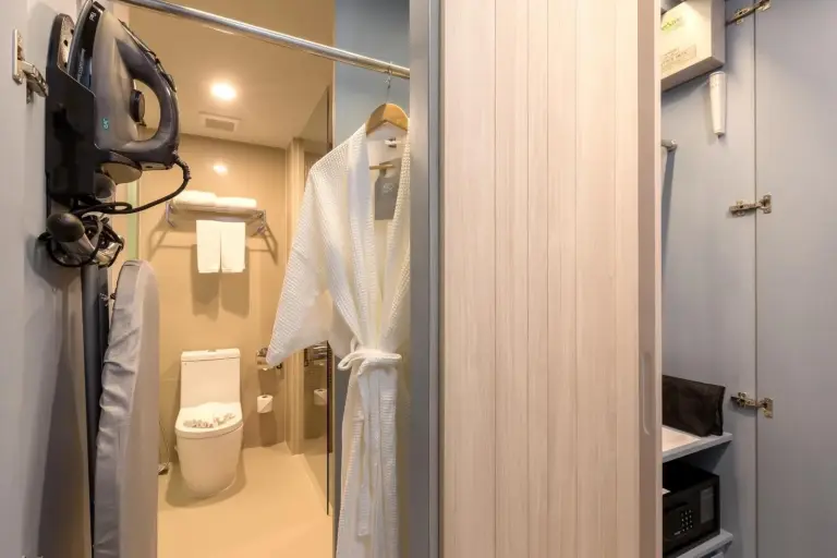 Bathroom entrance area at X10 Khaolak Resort in Khao Lak showing a bathrobe, safe storage, and toilet space.