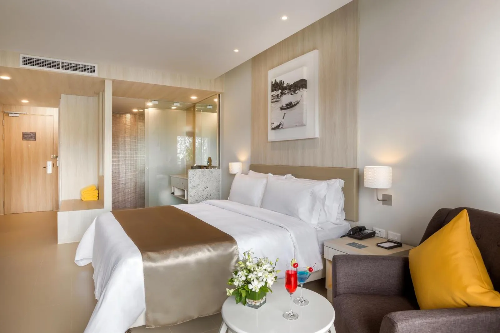 Stylish bedroom at X10 Khaolak Resort in Khao Lak with a king bed, lounge chair, and poolside touches.