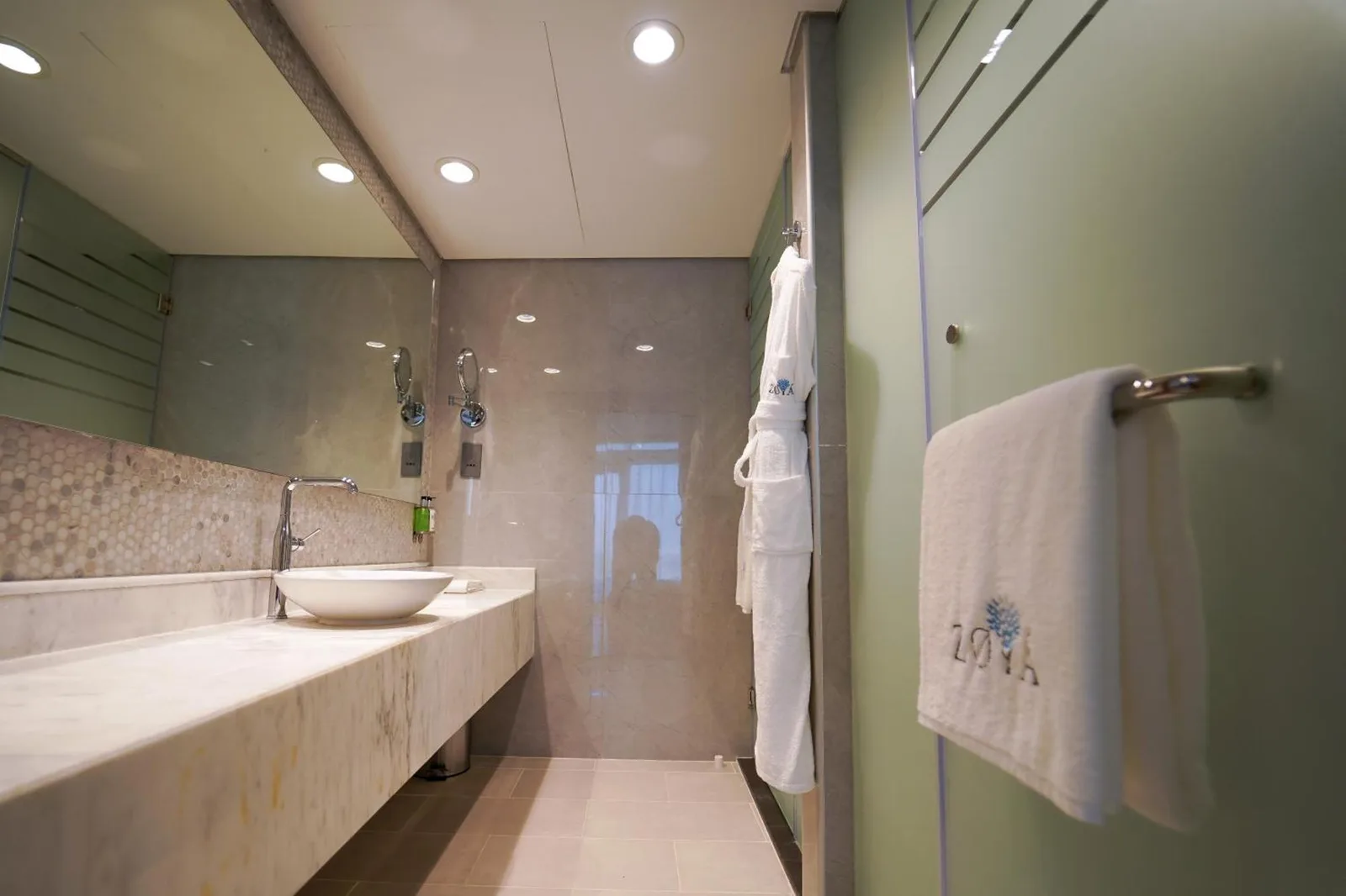 Contemporary bathroom at Zoya Health & Wellbeing Resort in Ajman with double vanity, glass shower, and bath amenities